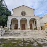 Torniamo all�esterno attraverso una delle due porte di accesso del teatro, che affiancano quella centrale di ingresso alla bianca chiesa...

